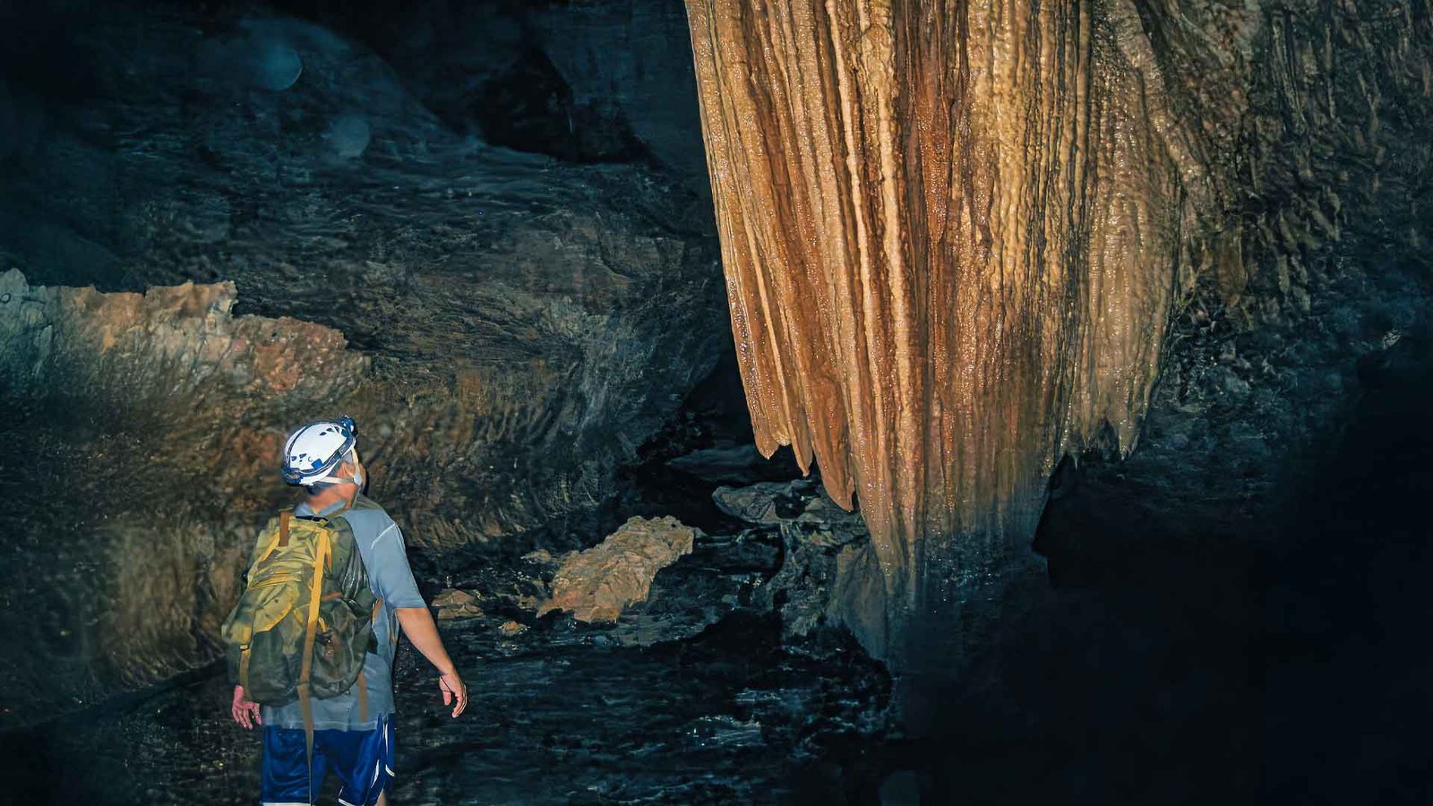 Tourist exploring stunning natural rock formations during the Actun Tunichil Muknal tour inside Belize’s sacred ATM cave system.