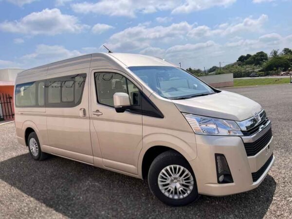 Golden Toyota HiAce van parked in Belize, ready for group transfer—part of professional Belize transportation services by Authentic Travel Belize.