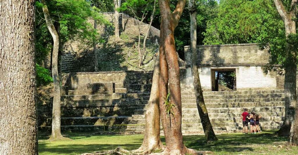 Cahal Pech Day Trip — couple with child walking in front of a Maya temple at Cahal Pech Archaeological Site, San Ignacio, Belize.