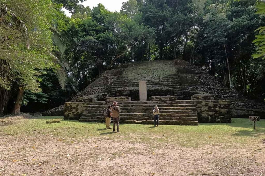 Visitors exploring the Mask Temple at Lamanai, one of the most iconic structures of this Maya archaeological site.