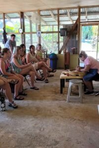 A group of visitors learning about the Maya ceramic production during the Pottery Workshop in Belize.