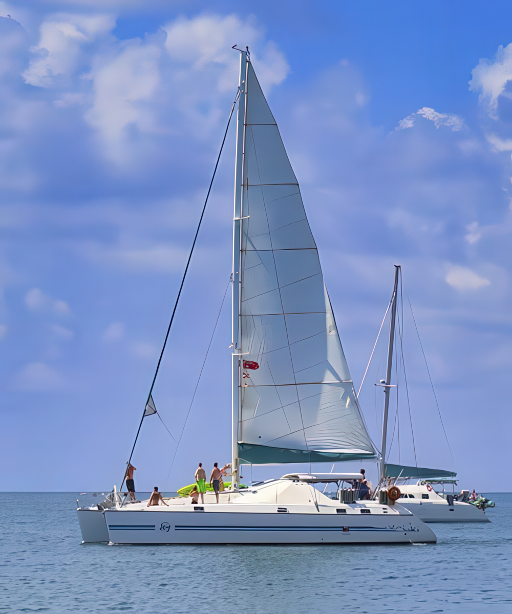 Sailing Placencia Catamaran sailing off the coast of Placencia, a scenic highlight of a Belize adventure travel experience.