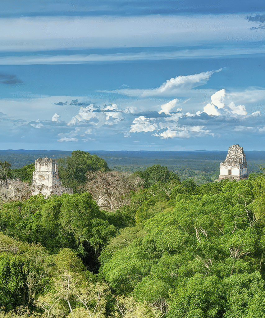 View of Tikal’s towering Maya temples rising above the rainforest canopy in Petén, a breathtaking stop on the Ultimate Belize and Guatemala Itinerary.