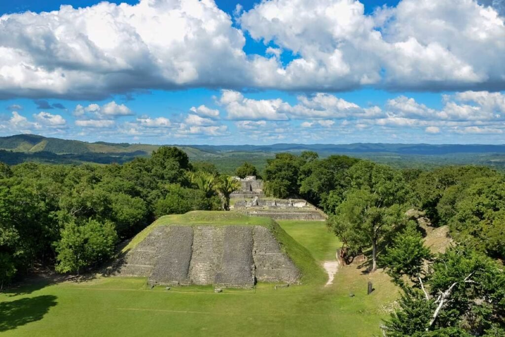 Panoramic view of El Castillo pyramid rising above the jungle canopy during the Xunantunich Mayan Ruins Tour.