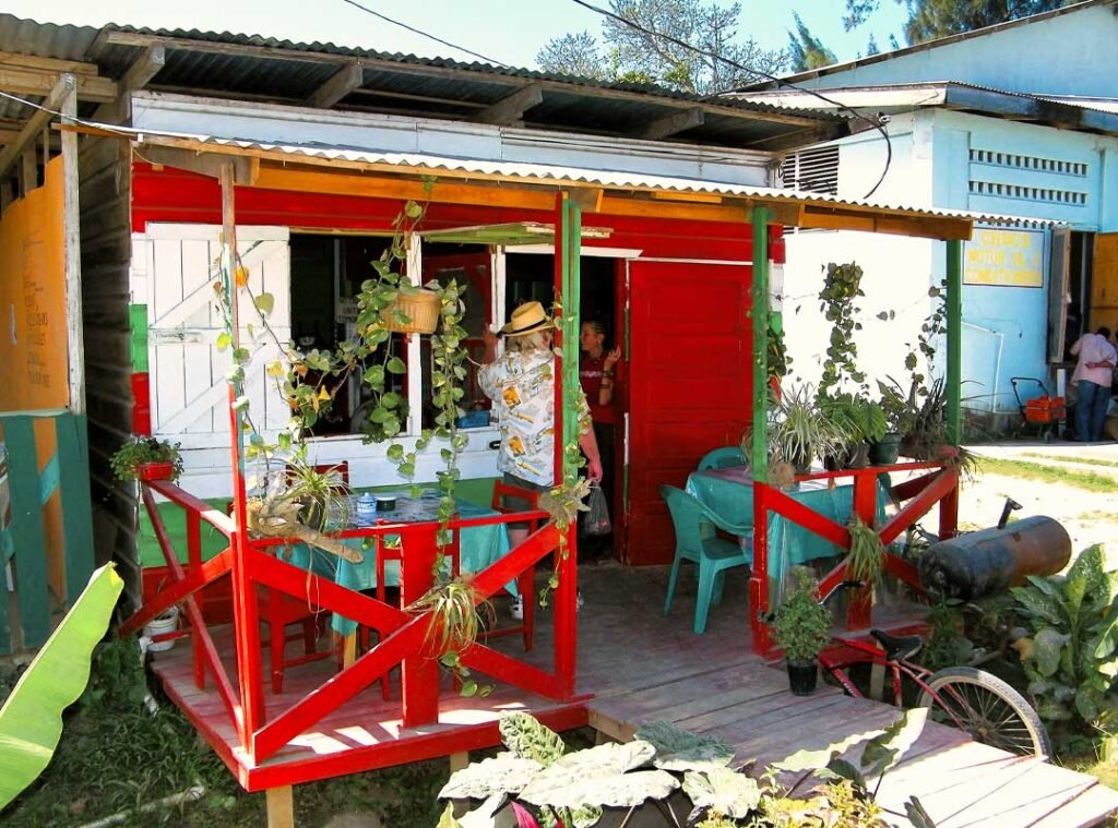 Vibrant local eatery on a Caribbean island near Belize, showcasing colorful walls, picnic tables, and island charm.