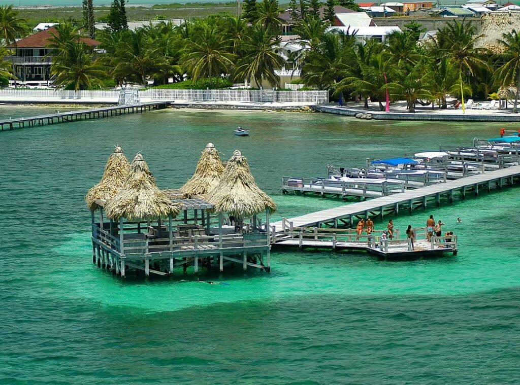 San Pedro pier stretching over the turquoise waters of Ambergris Caye, Belize, with clear skies and calm Caribbean sea.