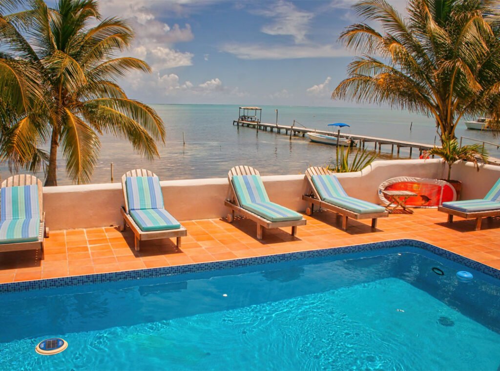 Island retreat with swimming pool and lounge chairs overlooking the coast of a Belizean caye Caulker.