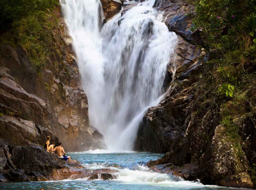 Big Rock Falls waterfall in Mountain Pine Ridge Belize surrounded by lush jungle and crystal-clear natural pools.