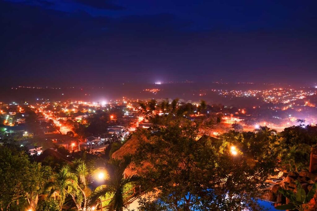 Night view of San Ignacio from Cahal Pech overlooking Cayo District Belize with city lights and surrounding hills.