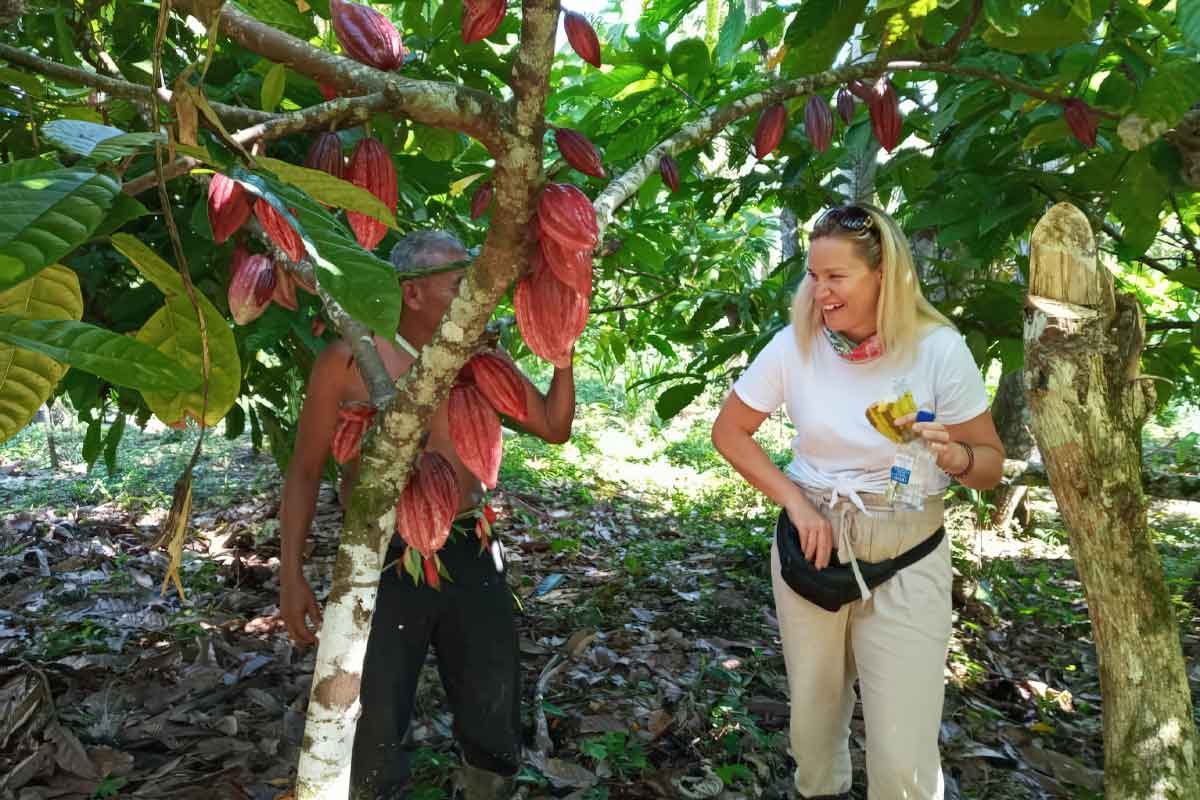 Woman learning about cacao from a Belize Maya farmer, highlighting cultural connection and hands-on discovery through Belize travel styles.