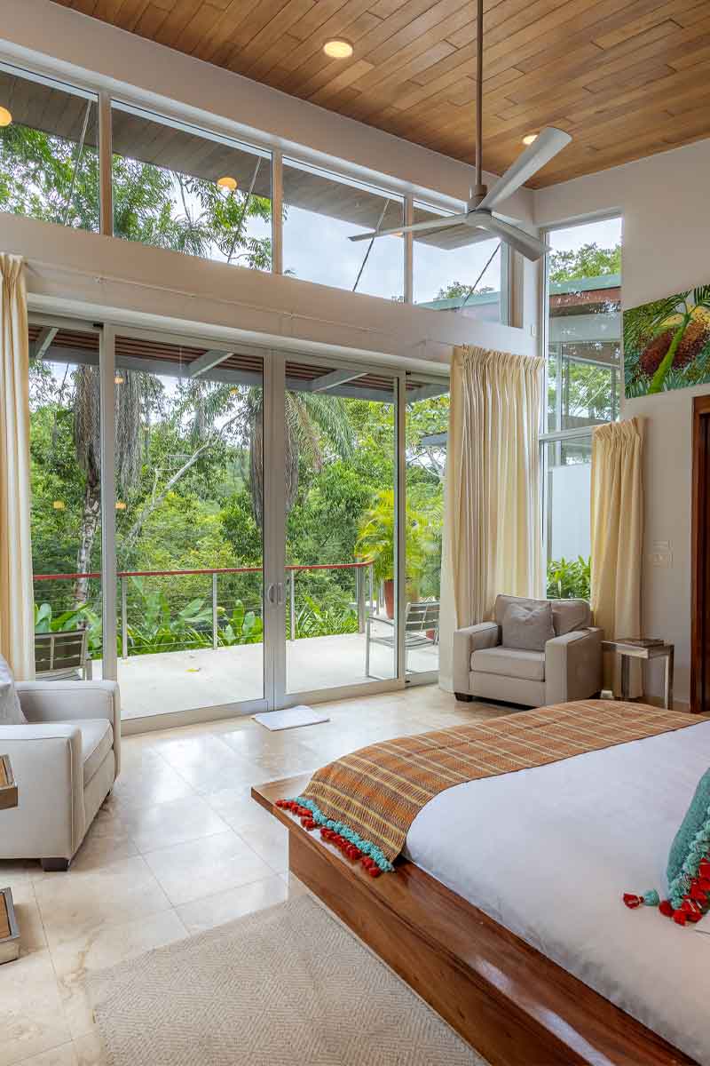 Jungle-View-Room Boutique jungle-view room in Belize with floor-to-ceiling windows, natural light, and forest views for Belize luxury and boutique travel.